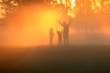 Family playing in the early morning fog