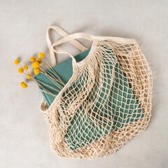 green book with yellow flowers in beige string bag 