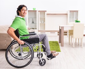 Young handsome man in wheelchair at home