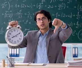 Young handsome math teacher in classroom