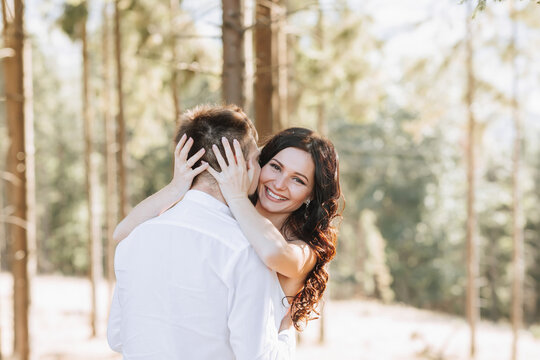 Young happy couple in love hugging smiling and having fun in the mountains. High quality photo. A girl in a beautiful white dress