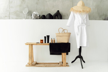 Modern bathroom interior. Panoramic view of tray with hairbrush, bottled soap dispenser and clean towels on wooden shelf. white coat on a hanger. rustic style. bathroom accessories concept