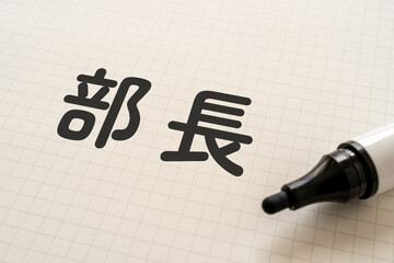 部長と書かれたノートとマーカー