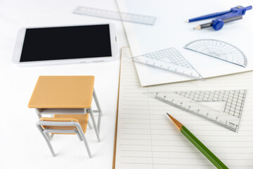 文房具と勉強机とスマートフォン。オンライン授業のイメージ