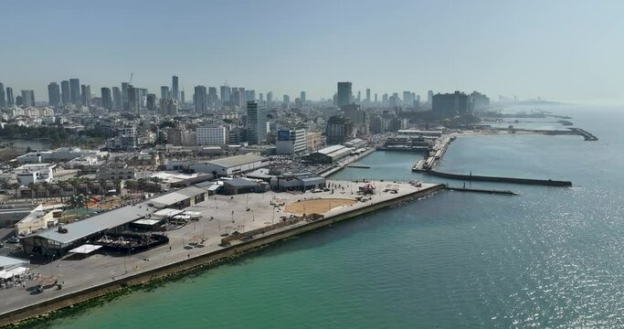 Aerial footage of the Tel Aviv Port Promenade with the Tel Aviv Ramat Gan skyline in the background. Filmed in C4K Apple ProRes 422 HQ