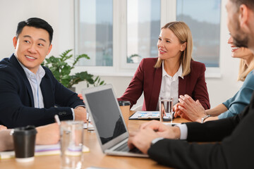 Businesswoman having meeting with her employees in office
