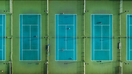 People playing tennis on a court. Aerial top-down drone.