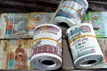 Rolls of Egypt money banknote bills of 100 and 50 EGP LE one hundred Egyptian and fifty Pounds on Kuwait dinars KWD one, half and quarter currency notes, Egyptian and Kuwaiti currency exchange rate - obrazy, fototapety, plakaty
