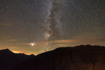 milky way over the mountains of the alps