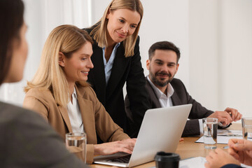 Businesswoman having meeting with her employees in office