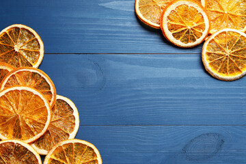 Dry orange slices on blue wooden table, flat lay. Space for text