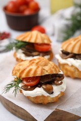 Delicious profiteroles with cream cheese, mushrooms, tomato and dill on board, closeup