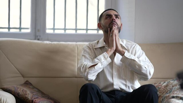 One desperate Arab young man feeling hopeless at home sitting on couch. Person suffering from mental crisis