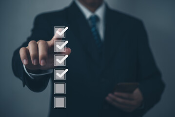 businessman using a virtual screen to check his to-do list. checking mark in a checkbox concept.