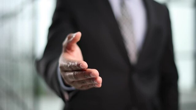 Close up crop image young businessman reaching out hand for shaking