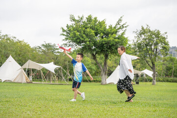Fototapeta premium Moms and Children Playing on the Camping Grassland in the Summer Park