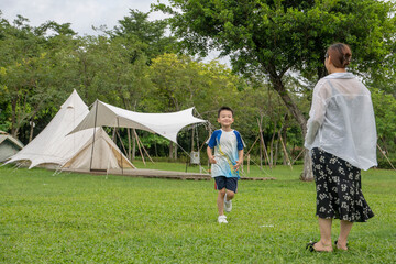Naklejka premium Moms and Children Playing on the Camping Grassland in the Summer Park