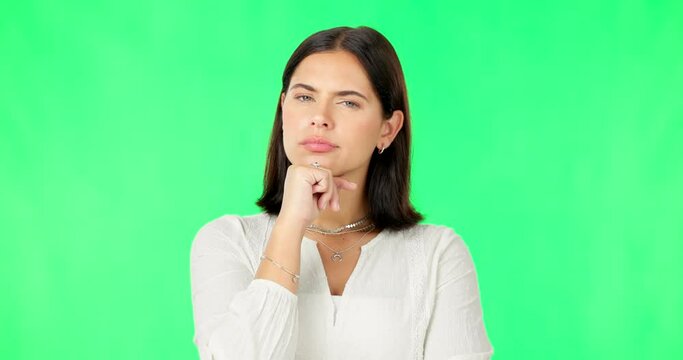 Face, idea and decision with a woman on a green screen background in studio to consider an option. Thinking, mind and contemplating with an attractive young female looking thoughtful on chromakey