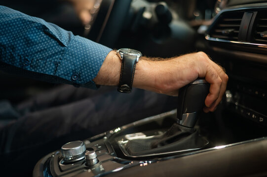 Close-up of a man's hand while shifting the automatic transmission of a car.
