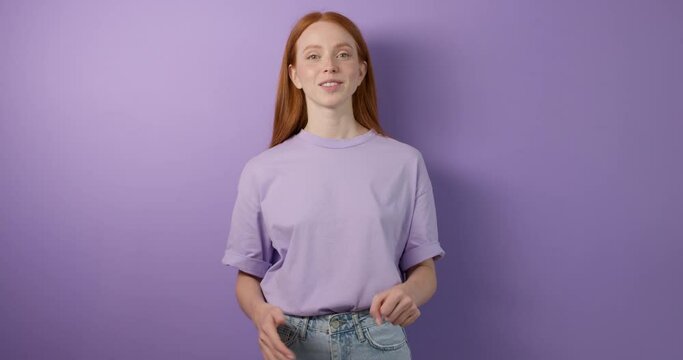 smiling friendly polite red-haired girl with stretched arms, looking at camera, asking What do you do I am studing education lifestyle free time spare time close up portrait isolated blue background