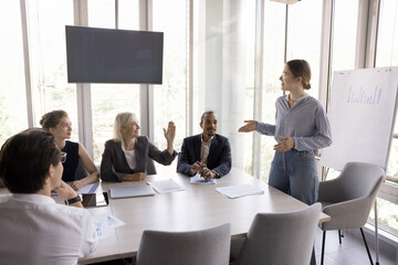 Trainee, intern asking question to presenter, speaker on corporate meeting, rising hand. Business teacher woman giving marketing lecture, training employees, talking to interns, audience
