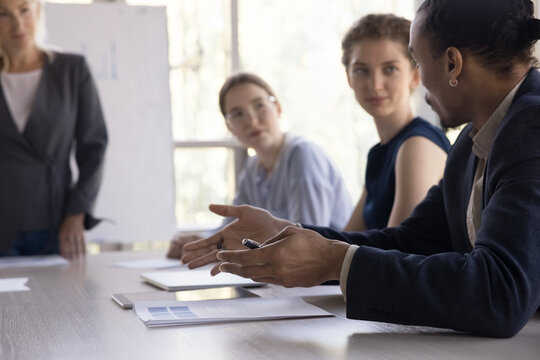 Hands of young Black business professional man talking to colleagues and boss woman on meeting, briefing, speaking to employees at conference table, telling idea on brainstorming - Powered by Adobe