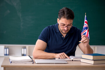 Male English language teacher in front of green board