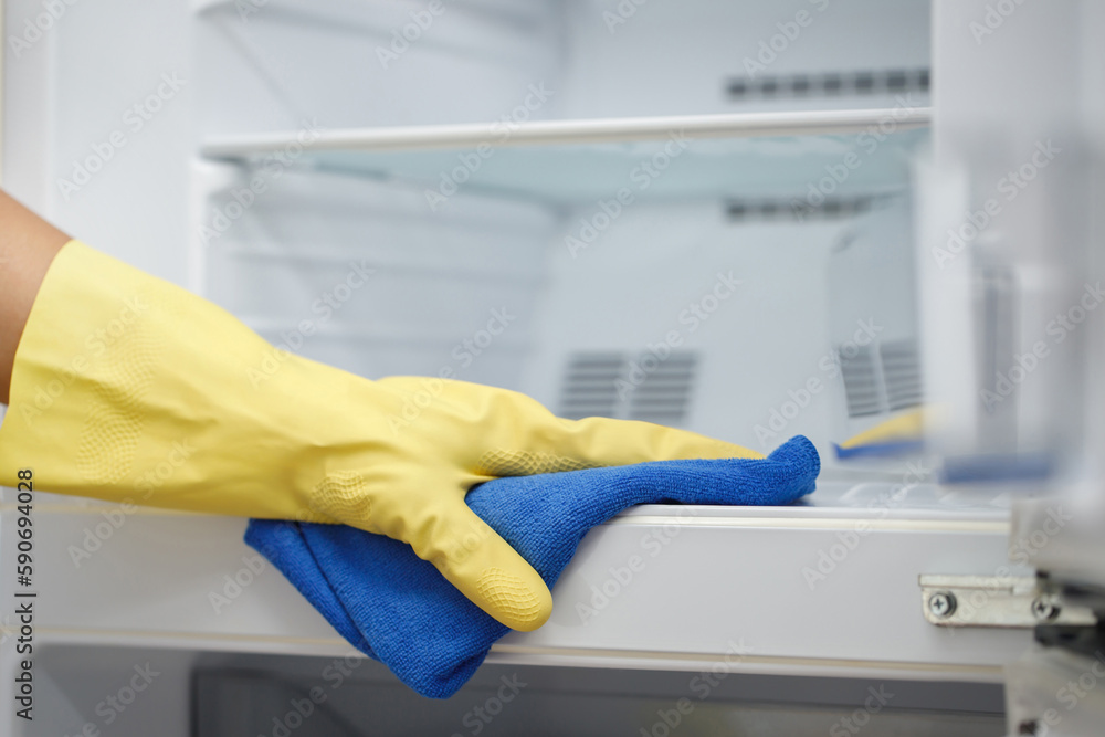 Wall mural employees use a cloth to clean the refrigerator.