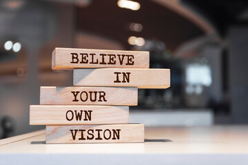 Wooden blocks with words 'Believe in your own vision'. Motivation concept