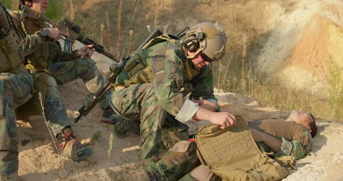 soldier is opening his bag, looking for rubber bandage and a tourniquet to relieve pain of his wounded pain slow motion