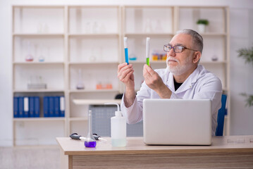 Old male chemist working at the lab