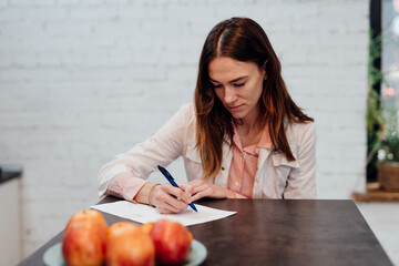 Female dietitian takes notes while sitting at her desk