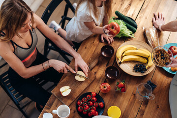Girls are making fruit salad and granola.