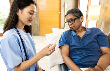 Fototapeta premium Health visitor and a senior woman during home visit.Worried senior man talking to her general practitioner visiting her at home during virus epidemic.