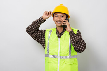 Young asian construction worker standing talking on mobile phone isolated on white background