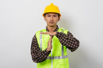 Young asian construction worker doing time out gesture isolated on white background