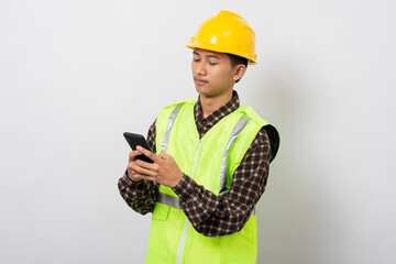 Young asian construction worker smiling happy using smartphone isolated on white background