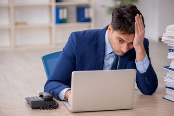 Young male employee and too much work in the office