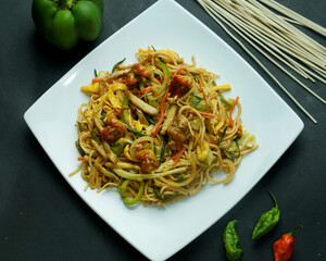 fried soba noodles with mushrooms, carrots, and peppers closeup on a plate. horizontal top view
