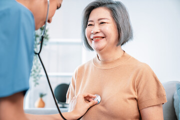 A contented retired senior woman being exterminated by her caregiver with a stethoscope at home....