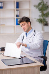 Fototapeta premium Young male doctor in telemedicine concept