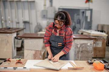 A Carpenter carefully measures, marks dimensions, and lays out reference lines on wood using scribe, divider, square, ruler, and caliper. The woodworking process need skills, experience, precision.