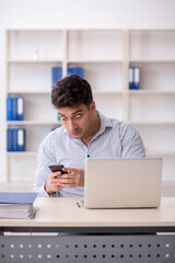 Fototapeta premium Young male employee working in the office