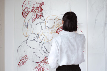 Female artist drawing painting with paint brush and black paint. Graphic Painting. Creating modern Art