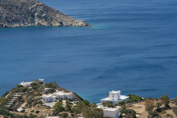 View of various whitewashed summer villas next to the Aegean Sea in Ios Greece