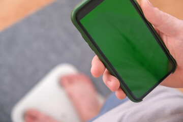 man stands on the scales. The guy is weighing himself. Floor scales for health. Weight control.