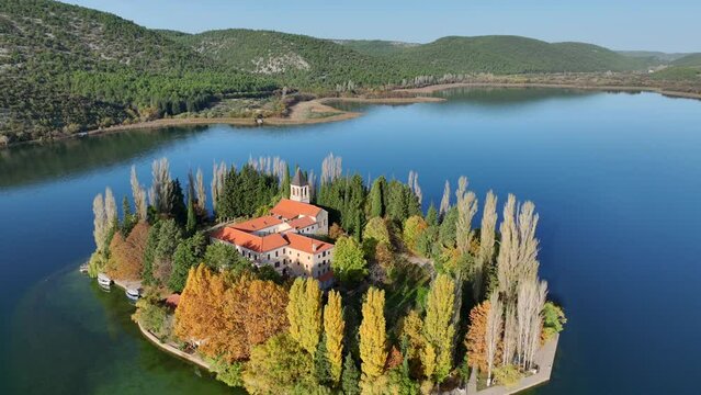 Aerial drone video circling Visovac island in Krka National Park in Croatia with monastery on it