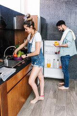 Obraz premium latin couple cooking together in the kitchen healthy food at home in Mexico, Hispanic people 