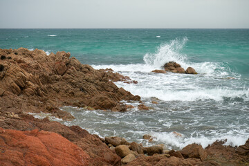 Stürmisches Meer mit hohen Wellen an den Felsen von Sardinien im Mittelmeer