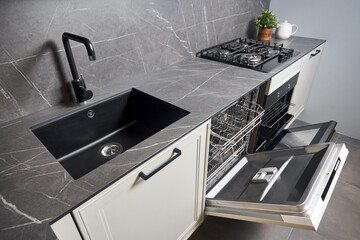 Contemporary kitchen with built-in opened dishwasher oven square black sink gas hob with grey...